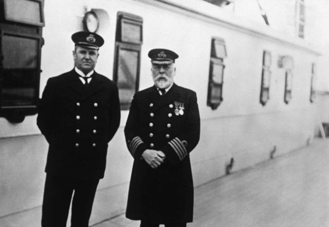 Thuyền trưởng Edward J. Smith (bên phải) người tuyên bố rằng: “Ngay cả ĐỨC CHÚA TRỜI cũng không thể đánh chìm con tàu này!” chụp trên boong tàu Titanic cùng đồng nghiệp, người quản lý Hugh Walter McElroy, 